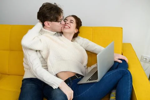 Portrait of a smiling young couple using laptop at home indoor Stock Photos