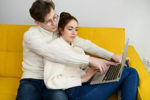 Portrait of a smiling young couple using laptop at home indoor Stock Photos