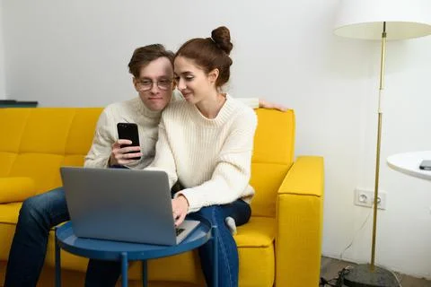 Portrait of a smiling young couple using laptop at home indoor Stock Photos