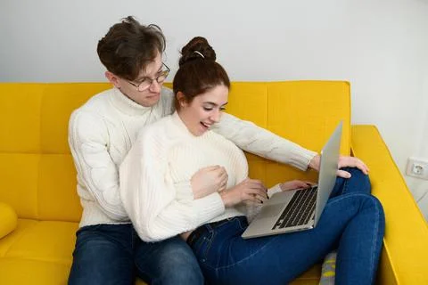 Portrait of a smiling young couple using laptop at home indoor Stock Photos