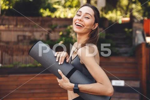 Portrait of a smiling young fitness girl standing outdoors Stock Photos