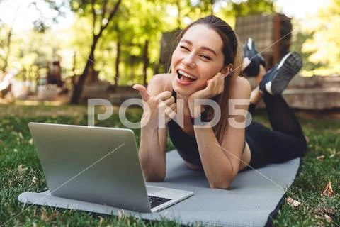 Portrait of a smiling young fitness girl using laptop Stock Photos