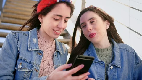 Portrait of smiling young friends scrolls through Instagram app feed on smart Stock Footage 106194167