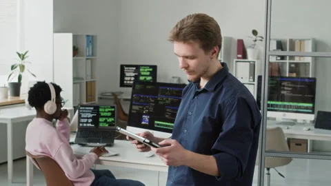 Portrait of Smiling Young Male Software Developer Using Tablet in Office Video stock 330125671