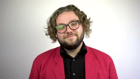 Portrait of a smiling young man with a beard in a red blazer. Video stock 137021767