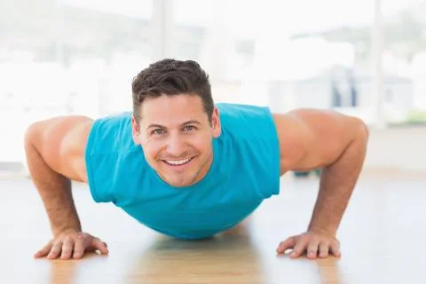Portrait of a smiling young man doing push ups Stock Photos