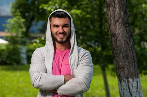 Portrait of smiling young man posing in park Stock Photos