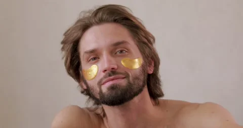 Portrait of smiling young man using korean eye patches for cooling skin Stock Footage 142527807