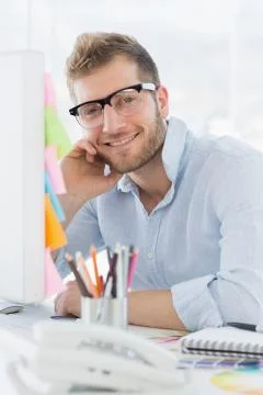 Portrait of a smiling young man using computer Stock Photos