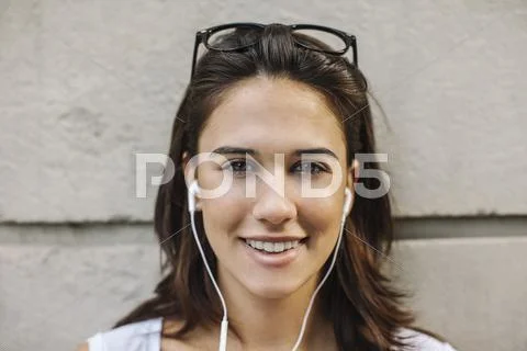 Portrait Of Smiling Young Woman With Ear Phones