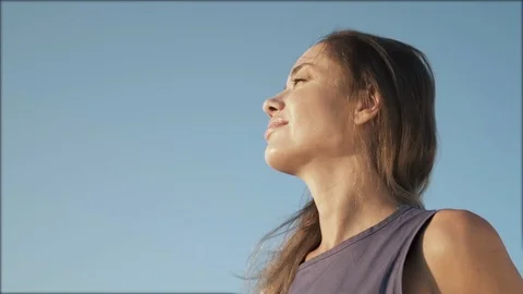 Portrait of a smiling young woman looking up into the blue sky. Stress free Stock Footage