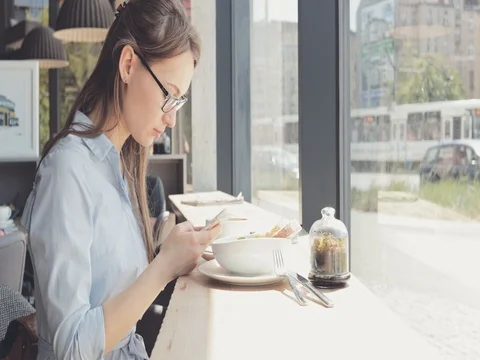 Portrait of Smiling Young Woman Using Smart Phone in a Cafe. 4K SLOW MOTION DCi Stock Footage