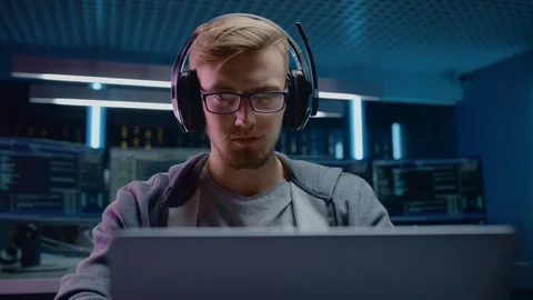 Portrait of Software Developer / Hacker / Gamer Wearing Glasses and Headset Sit Stock Footage 103577346
