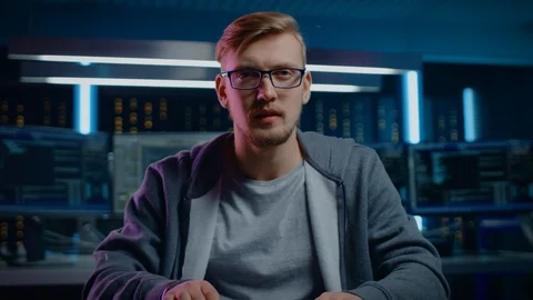 Portrait of Software Developer / Hacker Wearing Glasses Sitting at His Desk Stock Footage 103575831