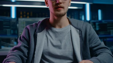 Portrait of Software Developer / Hacker Wearing Glasses Sitting at His Desk Stock Footage 103576408
