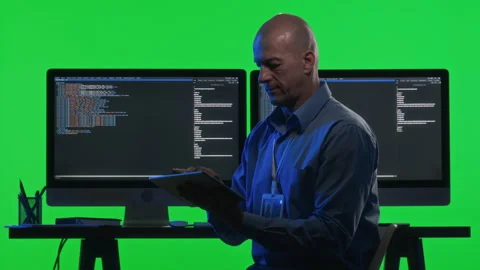 Portrait of Software Developer with Tablet and Computers against Green Wall Stock Footage 268815528
