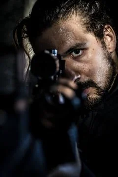 Portrait of a soldier aiming a gun sweating underground Stock Photos