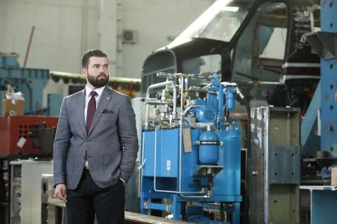 Portrait of a solid businessman controlling work process in a airplane factory. Stock Photos