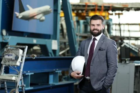 Portrait of a solid businessman controlling work process in a airplane factory. Stock Photos