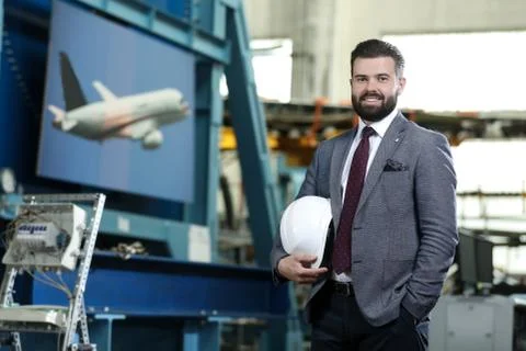 Portrait of a solid businessman controlling work process in a airplane factory. Stock Photos