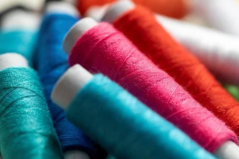 A portrait of some spools of colorful thread lying on some other rolls of fib Stock Photos