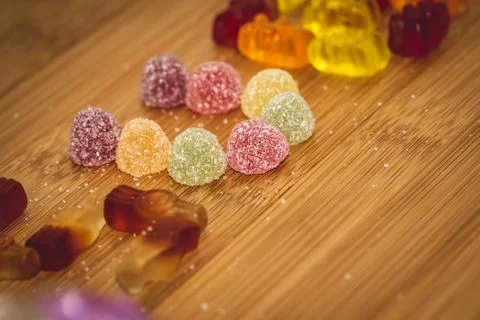 A portrait of some sugar coated sweets displayed on a wooden table. Around th Foto stock