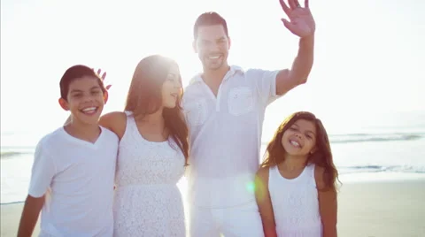 Portrait of Spanish family waving hands on their beach holiday Stock Footage