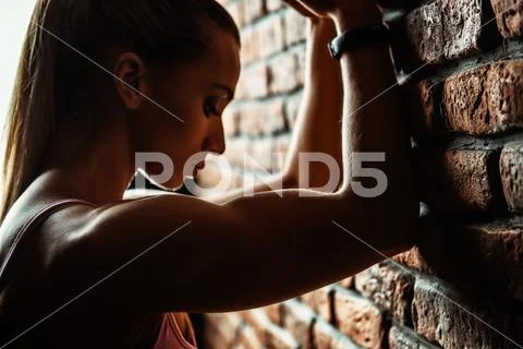 A portrait of a sporty young woman posing over the brick wall. Beauty, health Stock Photos