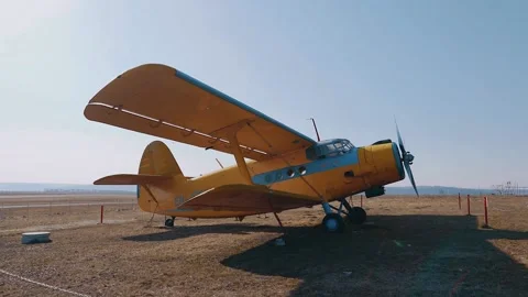 Portrait of a static, yellow helicopter with light blue stripes in the desert Stock Footage 155384895