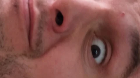 Portrait of a strange man who opened his eyes wide and shakes his head. Vertical Stock Footage 250352616