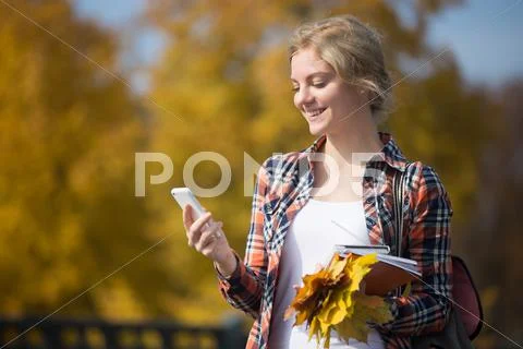 Portrait of student girl outsides, mobile phone in one hand Stock Photos