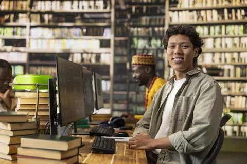 Portrait of student learning with desktop computer in library study room Stock Photos