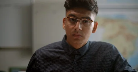 Portrait of student looking up from homework while in class Vidéo 118141166