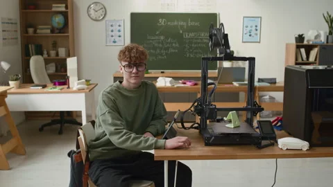 Portrait of Student Posing with Digital Tablet Next to 3D Printer in classroom Stockbeeldmateriaal 335695082