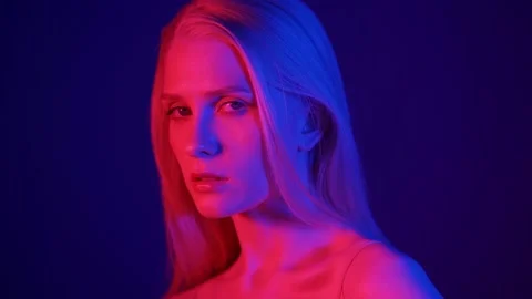 Portrait of a stylish blonde model in colored lighting. Fashionable photo Video stock 157679349
