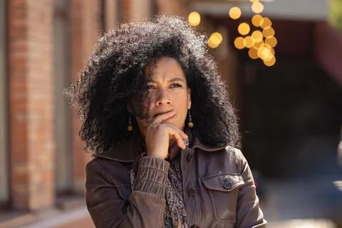 Portrait of stylish brooding young African American woman focused thinking about Stock Photos