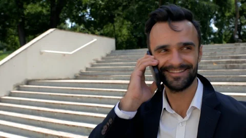 Portrait of a stylish young man with a beard, smiling and talking on the phone Stock Footage 113923353