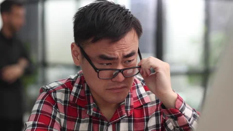 Portrait of a successful Asian software engineer working on a laptop at his desk 스톡 동영상 246334635