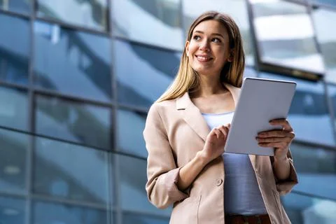 Portrait of successful woman using digital tablet in urban background. Business Stock Photos