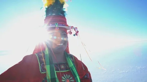 Portrait sun flare view of Bolivian woman on the Salar de Uyuni Salt flats in Stock Footage