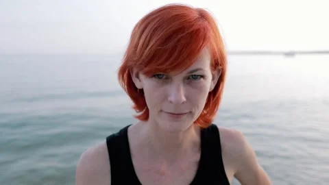 Portrait at sunset. A beautiful red-haired girl looks at the camera. Stock Footage 156300887