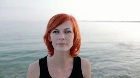 Portrait at sunset. A beautiful red-haired girl looks at the camera. Stock Footage 156300890