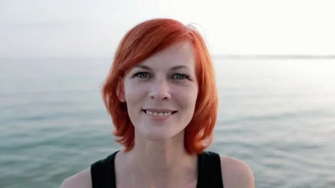 Portrait at sunset. A beautiful red-haired girl looks at the camera. Stock Footage 156300895