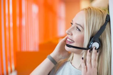  Portrait of support phone operator in headset at workplace. To provide ma... 写真素材