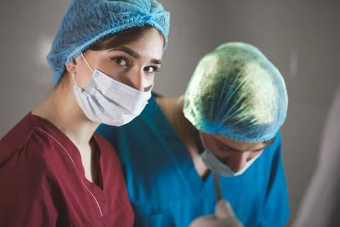 Portrait of surgeons at work, operating in uniform, looking at camera. Stock Photos