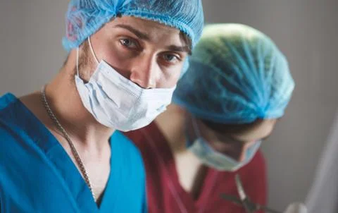 Portrait of surgeons at work, operating in uniform, looking at camera. Stock Photos