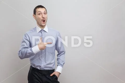 Portrait of surprised handsome bristle businessman in classic blue shirt stan Stock Photos