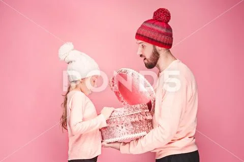Portrait of a surprised little girl with her father holding a Christmas present Stock Photos
