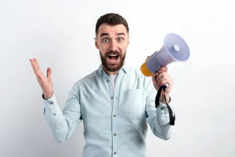 Portrait of surprised  man with open mouth holding megaphone against white ba Stock Photos