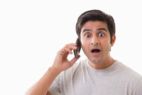 Portrait of surprised man using cell phone over white background Foto stock